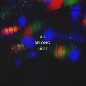 Dark abstract background with multicolored bokeh lights and the centered slogan 'ALL BELONG HERE'.